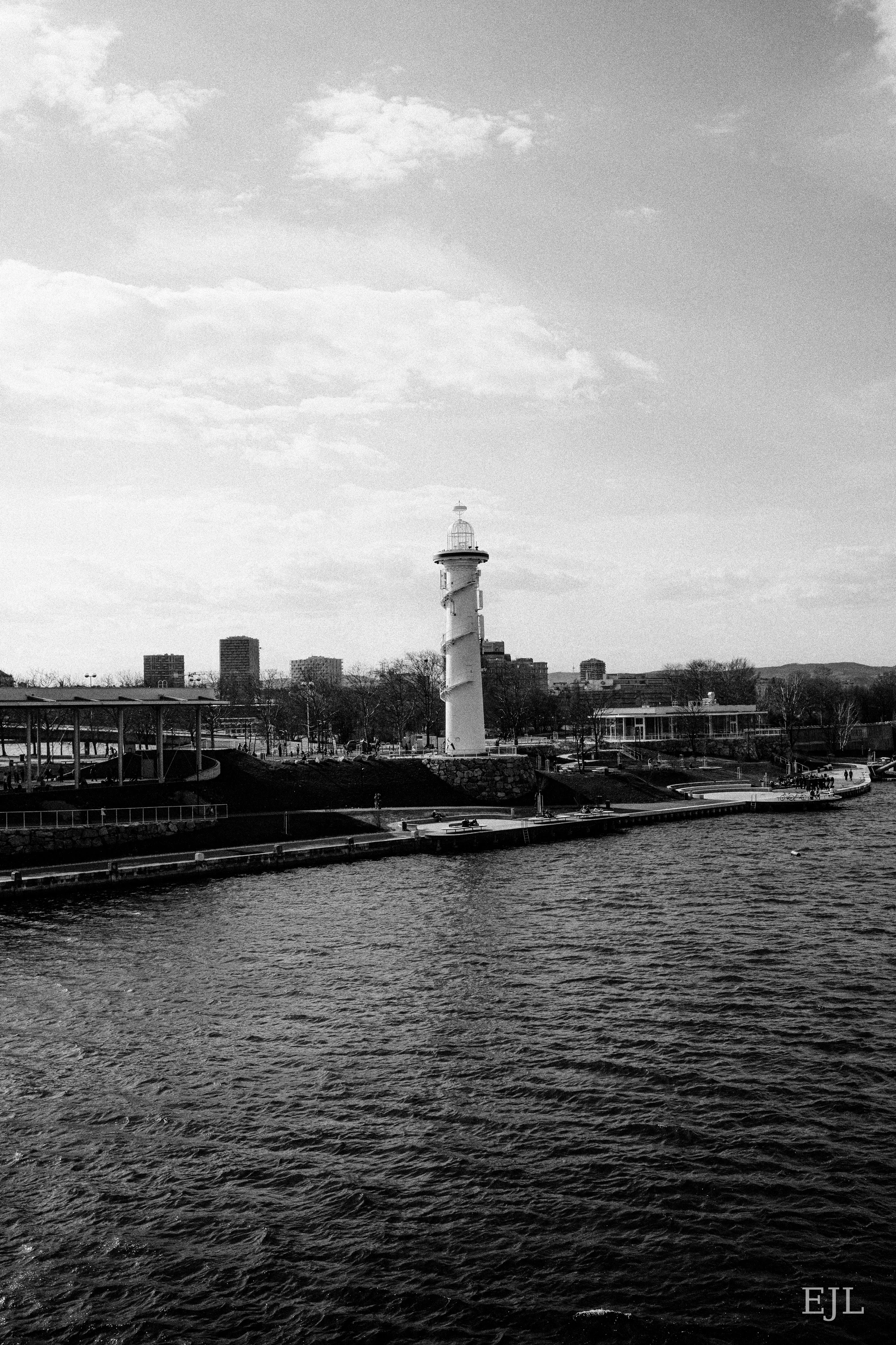 Black-and-white view of a striped lighthouse beside the river in Vienna