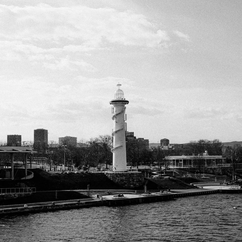 Black-and-white view of a striped lighthouse beside the river in Vienna